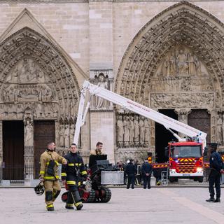 Le parvis de Notre-Dame, où des pompiers finissent de s'affairer après l'incendie qui a ravagé la cathédrale le 16 avril 2019. [AFP - Marie Magnin / Hans Lucas]
