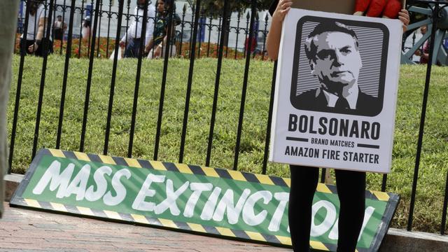 Un militant devant la Maison blanche proteste contre la destruction de l'Amazonie. [Keystone - EPA/SHAWN THEW]