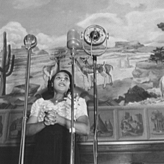 Marian Anderson en 1946 alors qu'elle interprète un Negro spiritual en direct à la radio lors de l'inauguration d'une peinture murale réalisée dans le bâtiment du Département de l'Intérieur des États-Unis, à Washington D.C.