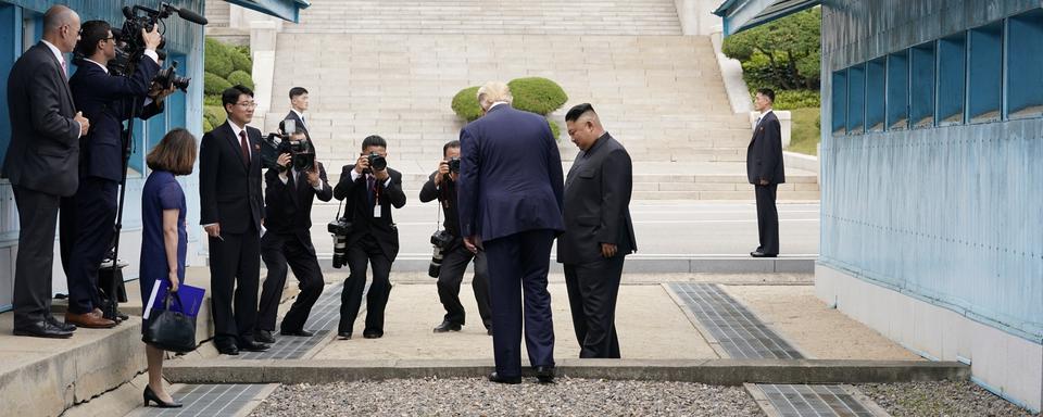 Donald Trump s'apprête à poser le pied en Corée du Nord, sous l'œil de Kim Jong-un. [Reuters - Kevin Lamarque]