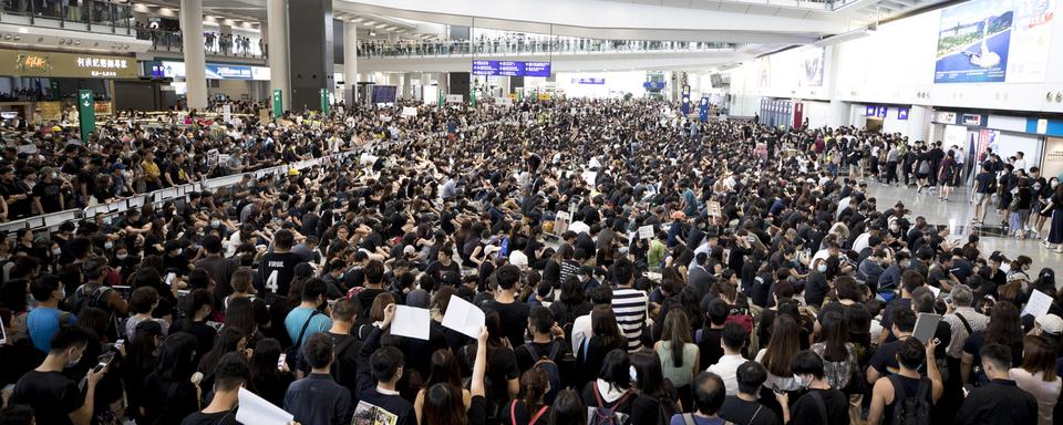 Quelque 5000 manifestants ont envahi le terminal principal de l'aéroport de Hong Kong le lundi 12 août 2019. [Keystone - AP Photo/Vincent Thian]