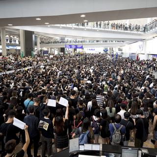 Quelque 5000 manifestants ont envahi le terminal principal de l'aéroport de Hong Kong le lundi 12 août 2019. [Keystone - AP Photo/Vincent Thian]