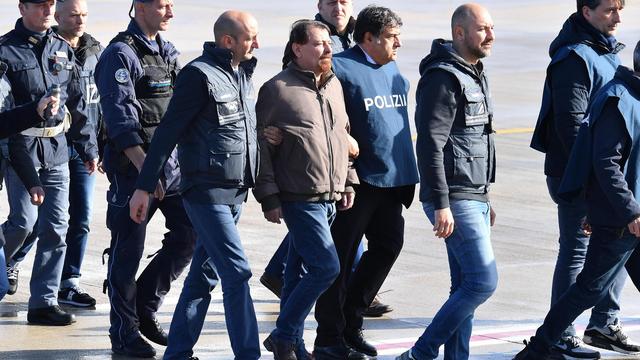 Cesare Battisti (centre, blouson brun et barbe) sous bonne garde à son arrivée à Rome lundi matin. [EPA - ETTORE FERRARI]