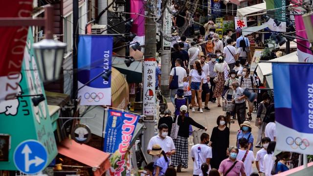 Des gens portent des masques contre le Covid-19 dans une rue marchande de Tokyo, le 1er août 2020. [AFP - Philip Fong]