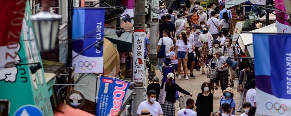 Des gens portent des masques contre le Covid-19 dans une rue marchande de Tokyo, le 1er août 2020. [AFP - Philip Fong]