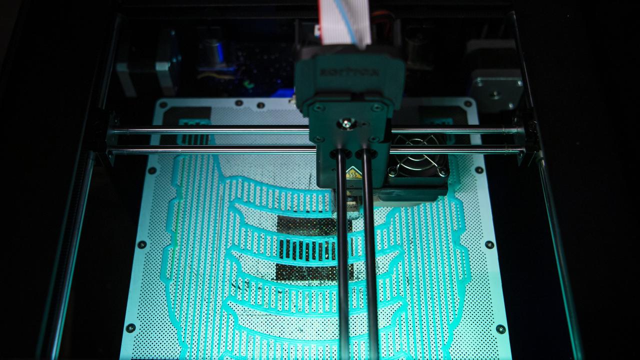 Une imprimante 3D du FabLab de Sion fabrique un modèle de visière de protection pour les professionnels de la santé. [Keystone - Jean-Christophe Bott]