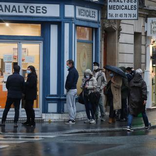 Des personnes attendent de recevoir un test devant un centre médical à Paris. [Keystone - EPA/Mohammed Badra]