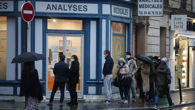 Des personnes attendent de recevoir un test devant un centre médical à Paris. [Keystone - EPA/Mohammed Badra]