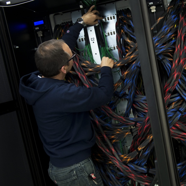 Un technicien analyse le câblage d'un super-ordinateur du CSCS à Lugano. [Keystone - Gabriele Putzu]