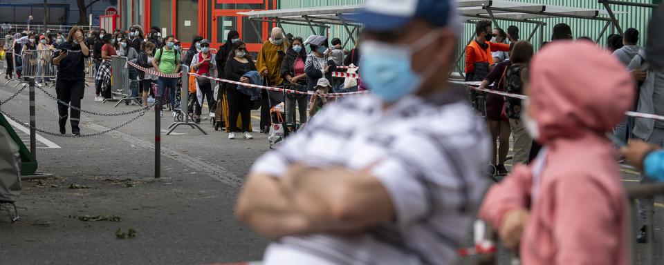 Une file d'attente lors d'une distribution de nourriture à Genève le 23 mai. [Keystone - Martial Trezzini]