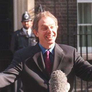 Le Premier ministre Tony Blair devant le 10 Downing Street, vendredi 8 mai 1998. Durant sa période à la tête du Parti travailliste (Labour Party), puis comme chef du gouvernement, Tony Blair réforme en profondeur l'idéologie et la pratique du travaillisme britannique, largement converti à l'économie de marché. [Keystone/AP - REBECCA NADEN]