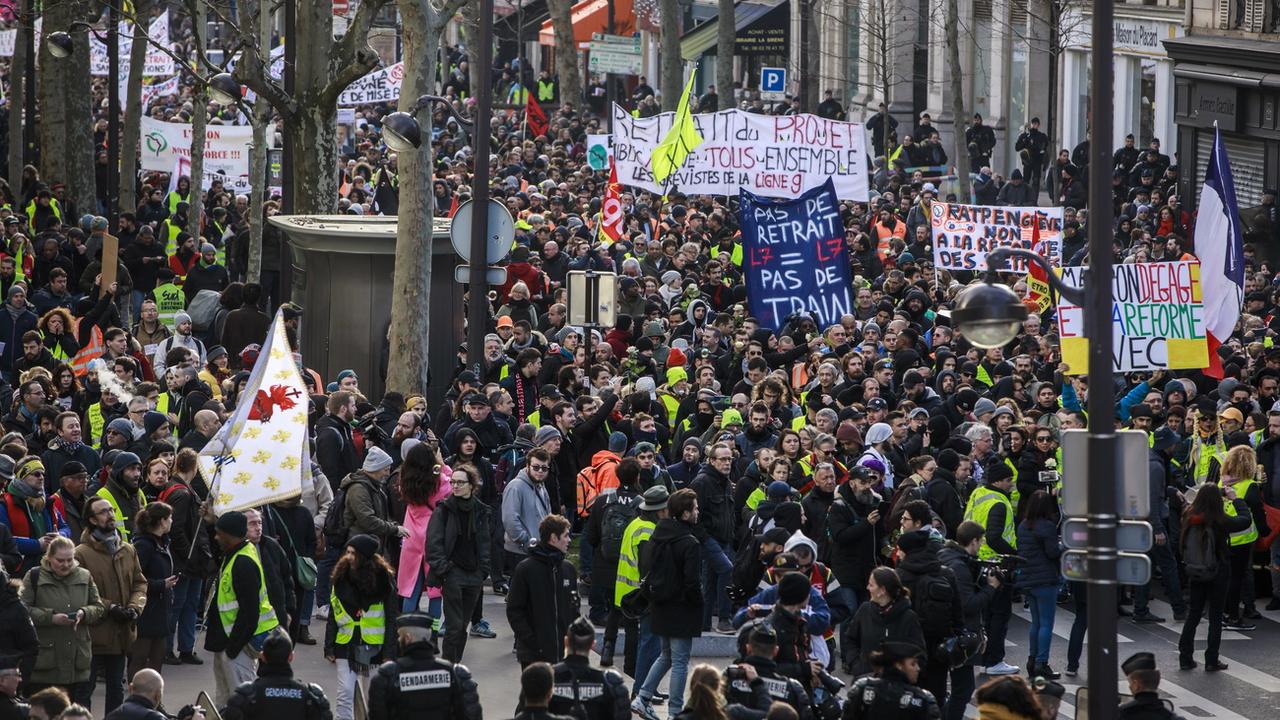 Des manifestants contre la réforme des retraites dans les rues de Paris. [Keystone/EPA - Christophe Petit Tesson]