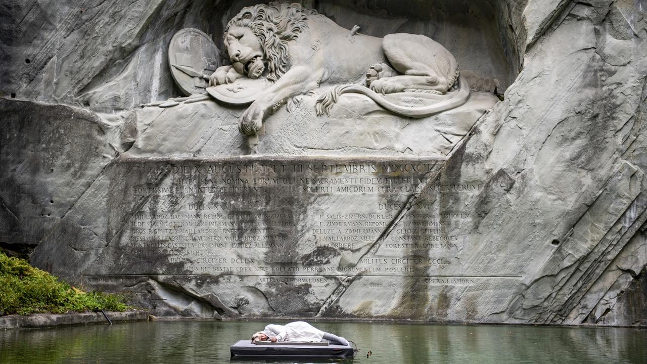 L'artiste Barbara Kiener dans une performance devant le Lion de Lucerne. [Keystone - Urs Flueeler]