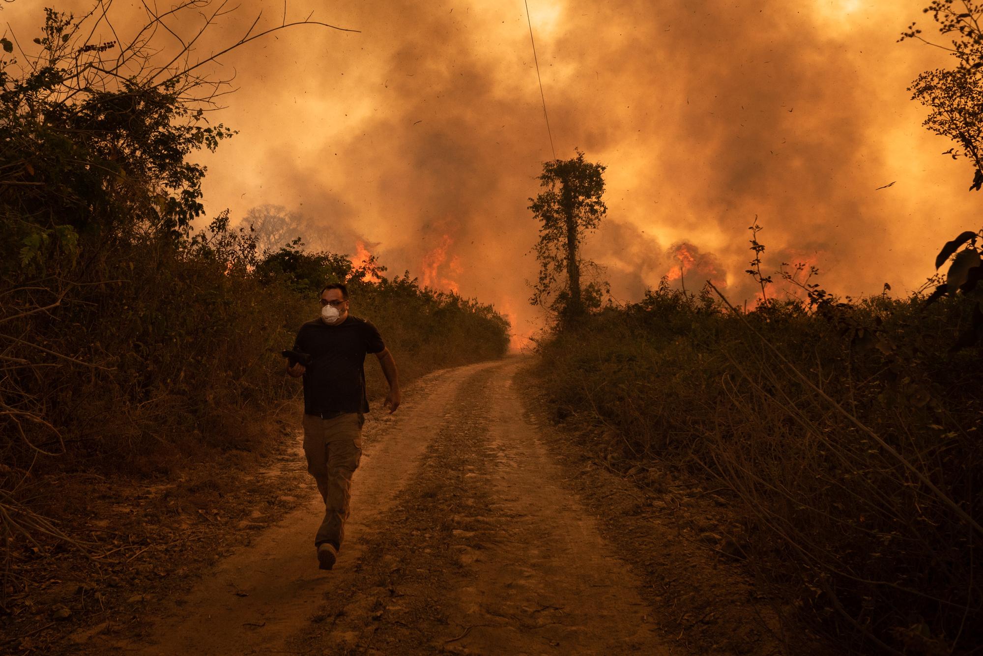 Un homme fuit l'incendie qui dévaste la région de Mato Grosso, dans le Pantanal brésilien, le 19 août 2020. [NurPhoto/AFP - Gustavo Basso]