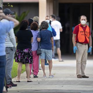 Des individus font la queue en dehors du bureau de vote en Floride. [The Palm Beach Post via AP - Lannis Waters]