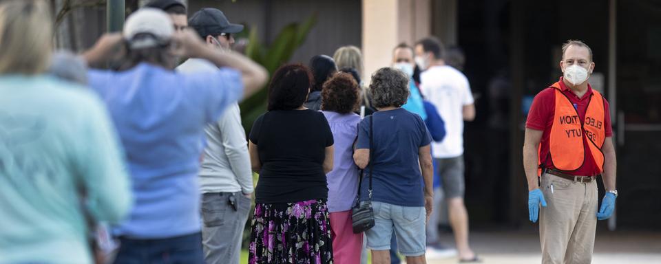 Des individus font la queue en dehors du bureau de vote en Floride. [The Palm Beach Post via AP - Lannis Waters]