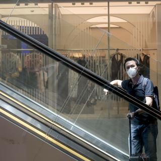 Un touriste portant un masque de protection à l'aéroport de Singapour. [Keystone - Wallace Woon]