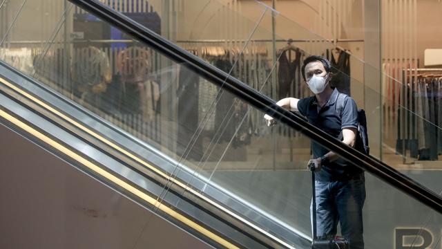 Un touriste portant un masque de protection à l'aéroport de Singapour. [Keystone - Wallace Woon]