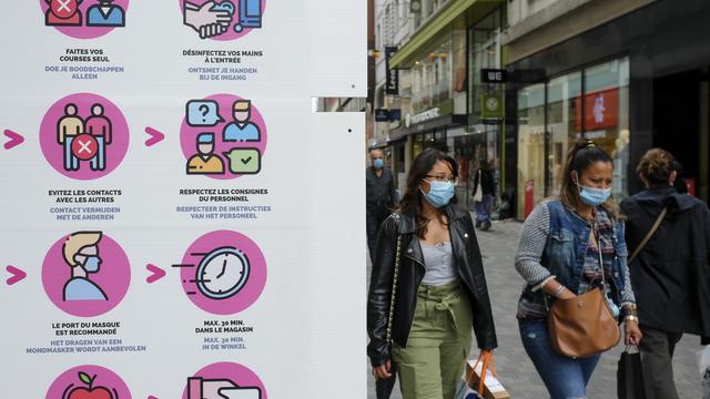 Des passantes dans une rue du centre-ville de Bruxelles. [Keystone/EPA - Julien Warnand]