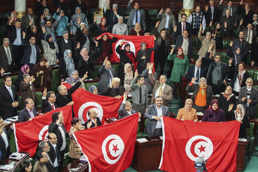 Les membres de l'Assemblée nationale constituante de Tunisie célèbrent l'adoption de la nouvelle constitution. Tunis, le 26 janvier 2014. [AP/Keystone - Aimen Zine]