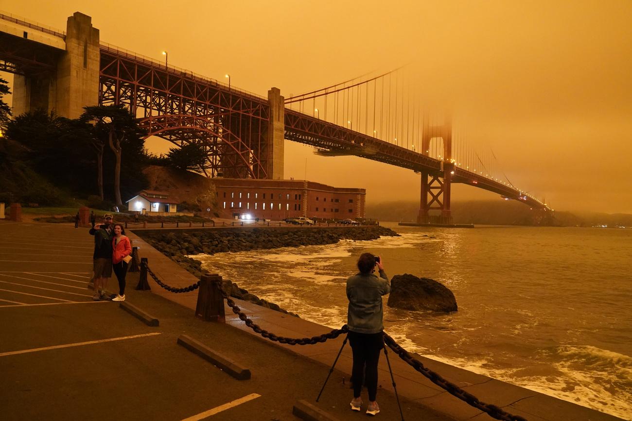 Des habitants prennent des photos du fameux pont suspendu du Golden Gate. [Keystone/AP Photo - Eric Risberg]