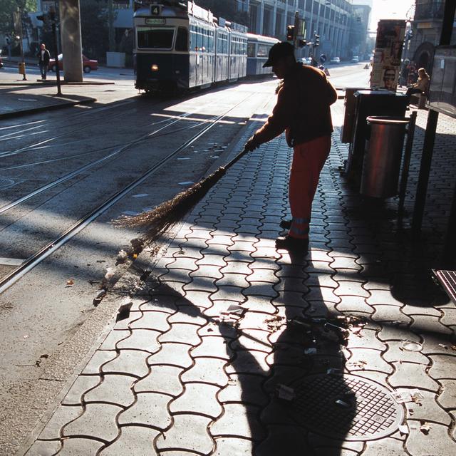 Un balayeur nettoie la rue. [Keystone - Gaetan Bally]