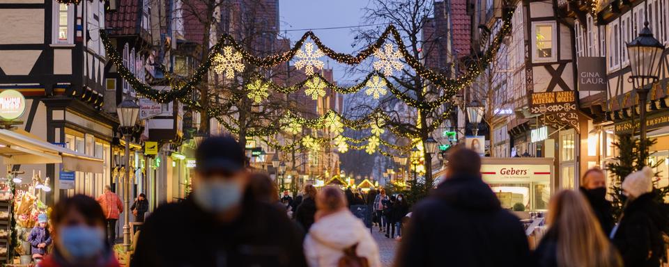 Des passants masqués dans une rue marchande de Celle, en Allemagne, le 12 décembre 2020. [Keystone - Ole Spata]