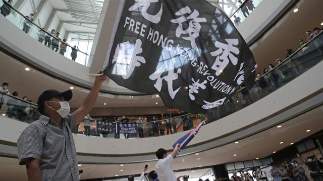 Les protestations continuent à Hong Kong, tandis que les batailles de visas se poursuivent entre la Chine et les États-Unis. [Keystone - Kin Cheung]