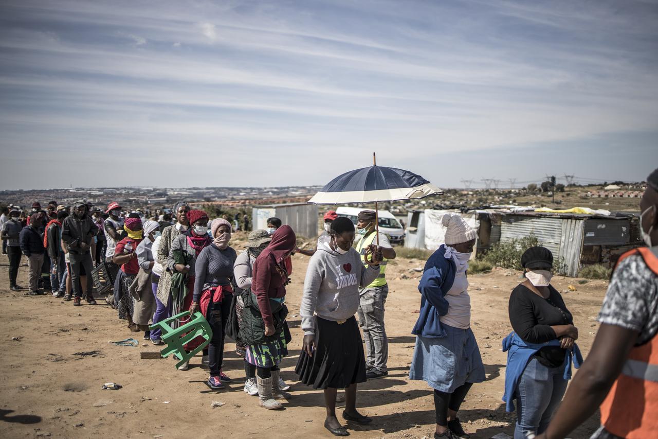 Des milliers d'habitants déshérités du quartier d'Olievenhoutbosch ont patienté pour recevoir 2200 tonnes de nourriture et d'équipements – masques ou gel hydroalcoolique – distribués par une ONG. [AFP - Marco Longari]