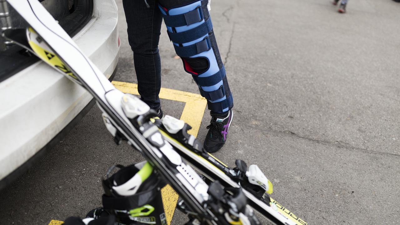 Une femme porte un attelle à la jambe des suites d'un accident de ski. [Keystone - Gaetan Bally]