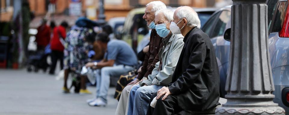 Des retraités sur un banc. [Keystone - EPA/Riccardo Antimiani]