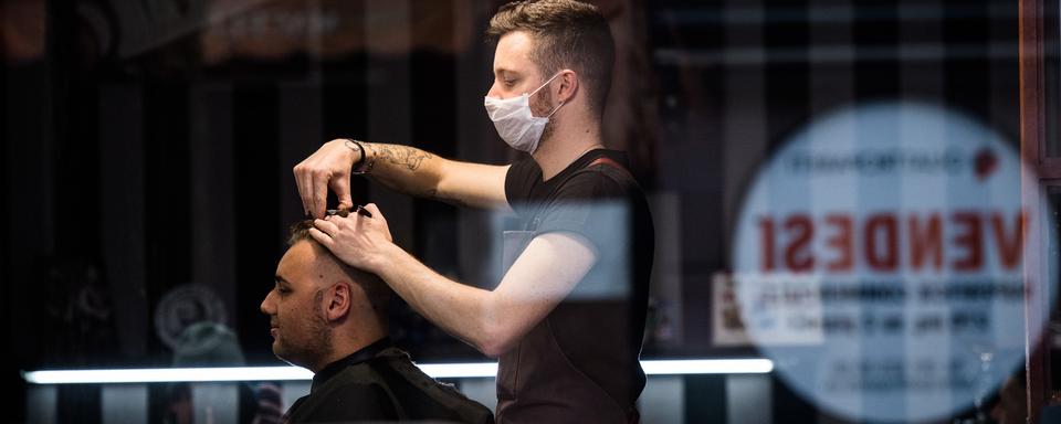 Un coiffeur au Tessin, le 14 mars. [Keystone - Ti-Press/Alessandro Crinari]