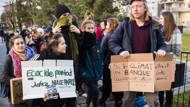 Des personnes venues soutenir les douze activistes du climat lors de l'ouverture du procès. [Keystone - Jean-Christophe Bott]