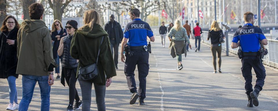 Des policiers patrouillent au milieu des promeneurs autour de la Rade de Genève, le 28 mars 2020. [Keystone - Salvatore Di Nolfi]