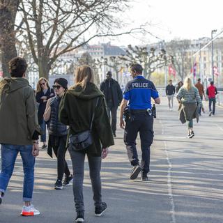 Des policiers patrouillent au milieu des promeneurs autour de la Rade de Genève, le 28 mars 2020. [Keystone - Salvatore Di Nolfi]