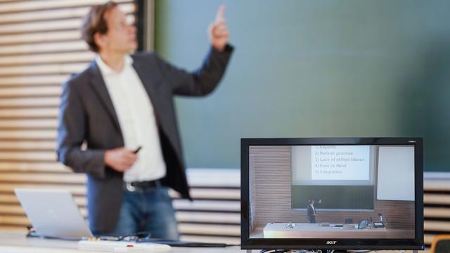 Un professeur donne son cours en vidéoconférence à ses étudiants durant la pandémie de Covid-19. [DPA/Keystone - Uwe Anspach]