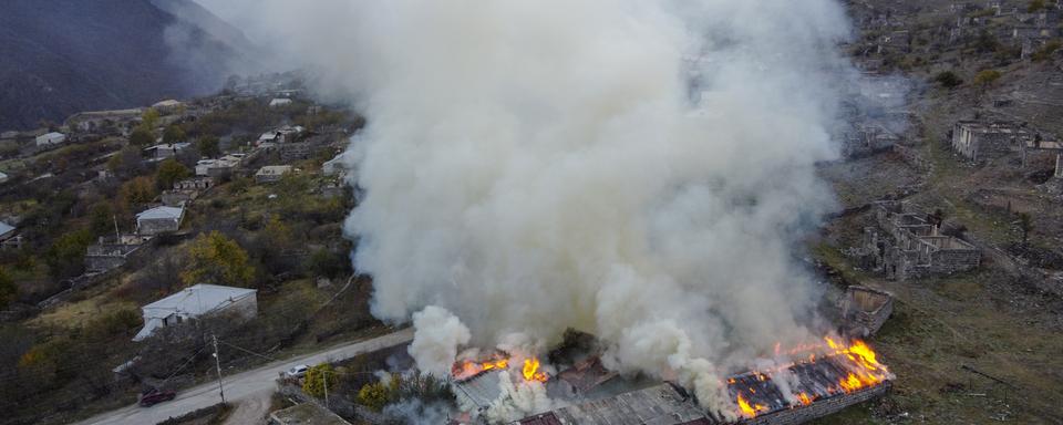 Une maison en feu dans le Haut-Karabakh. [Keystone - AP Photo/Dmitry Lovetsky]