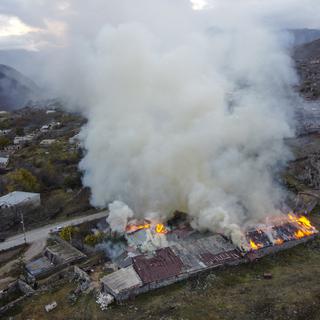 Une maison en feu dans le Haut-Karabakh. [Keystone - AP Photo/Dmitry Lovetsky]