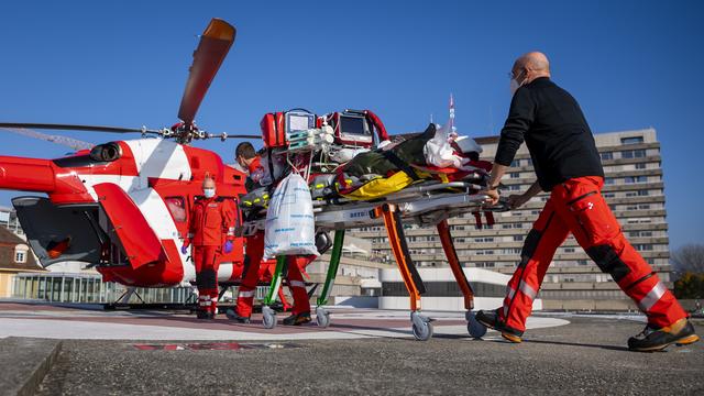 Un patient atteint du Covid-19 est transféré par hélicoptère du CHUV, à Lausanne, vers l'Hôpital de l'Île, à Berne. [Keystone - Jean-Christophe Bott]