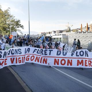 Des personnes défilent avec des banderoles "Sauvons la forêt du Flon", lors d'une manifestation. [Keystone - Salvatore Di Nolfi]