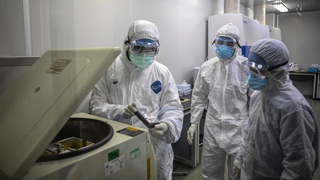 Des scientifiques chinois travaillent sur le Covid-19. [Keystone - Alex Plaveski]