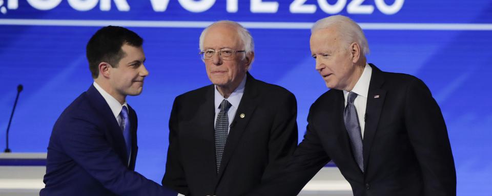 Le jeune Pete Buttigieg face aux vétérans Bernie Sanders et Joe Biden lors du d'un débat dans le New Hampshire. [Keystone - AP Photo/Charles Krupa]