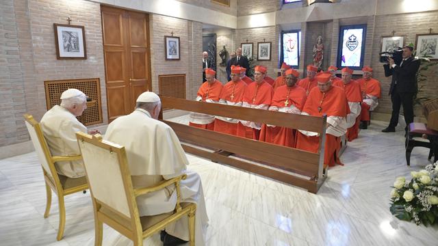 L'ancien pape Benoît XVI (à gauche) et l'actuel, François (à droite) en 2018 devant les nouveaux cardinaux. [Vatican media/AFP]