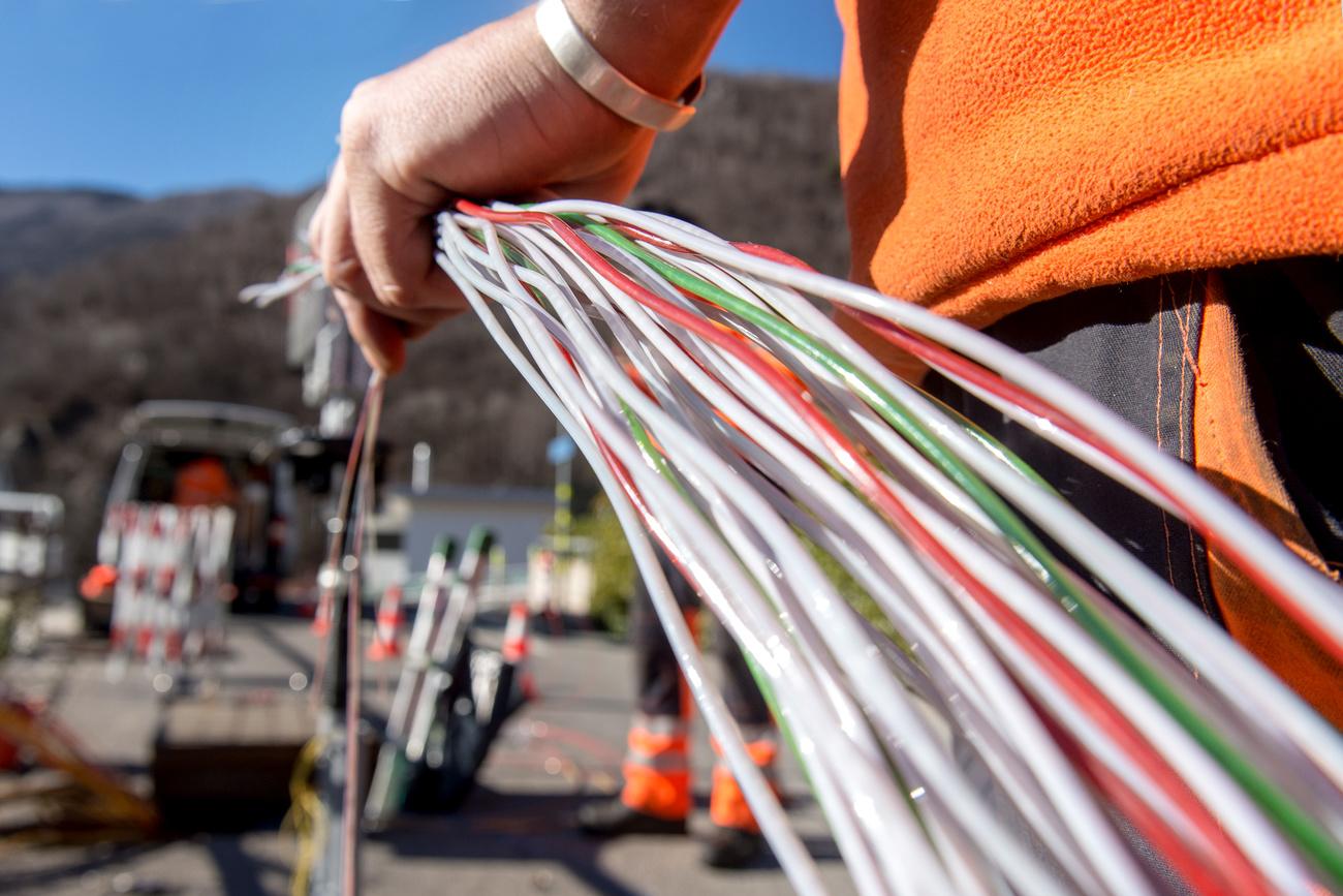 Un travailleur de Swisscom installe de la fibre optique près de Bellinzone (TI), en février 2015. [Keystone - Carlo Reguzzi]