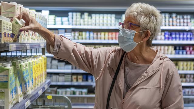 Une cliente masquée dans un magasin bâlois. [Keystone - Georgios Kefalas]