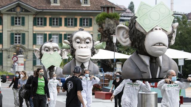 Greenpeace accuse la FINMA, la BNS et les autorité de surveillance des caisses de pension de favoriser le réchauffement climatique [Keystone - Peter Schneider]