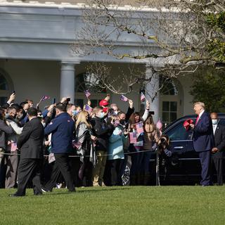 Samedi 31 octobre: Donald Trump distribue des casquettes avant de partir pour un meeting. [Keystone/AP Photo - Alex Brandon]