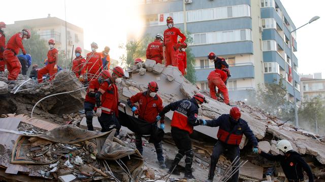 Des secouristes sortent un corps d'un immeuble détruit de la ville d'Izmir.