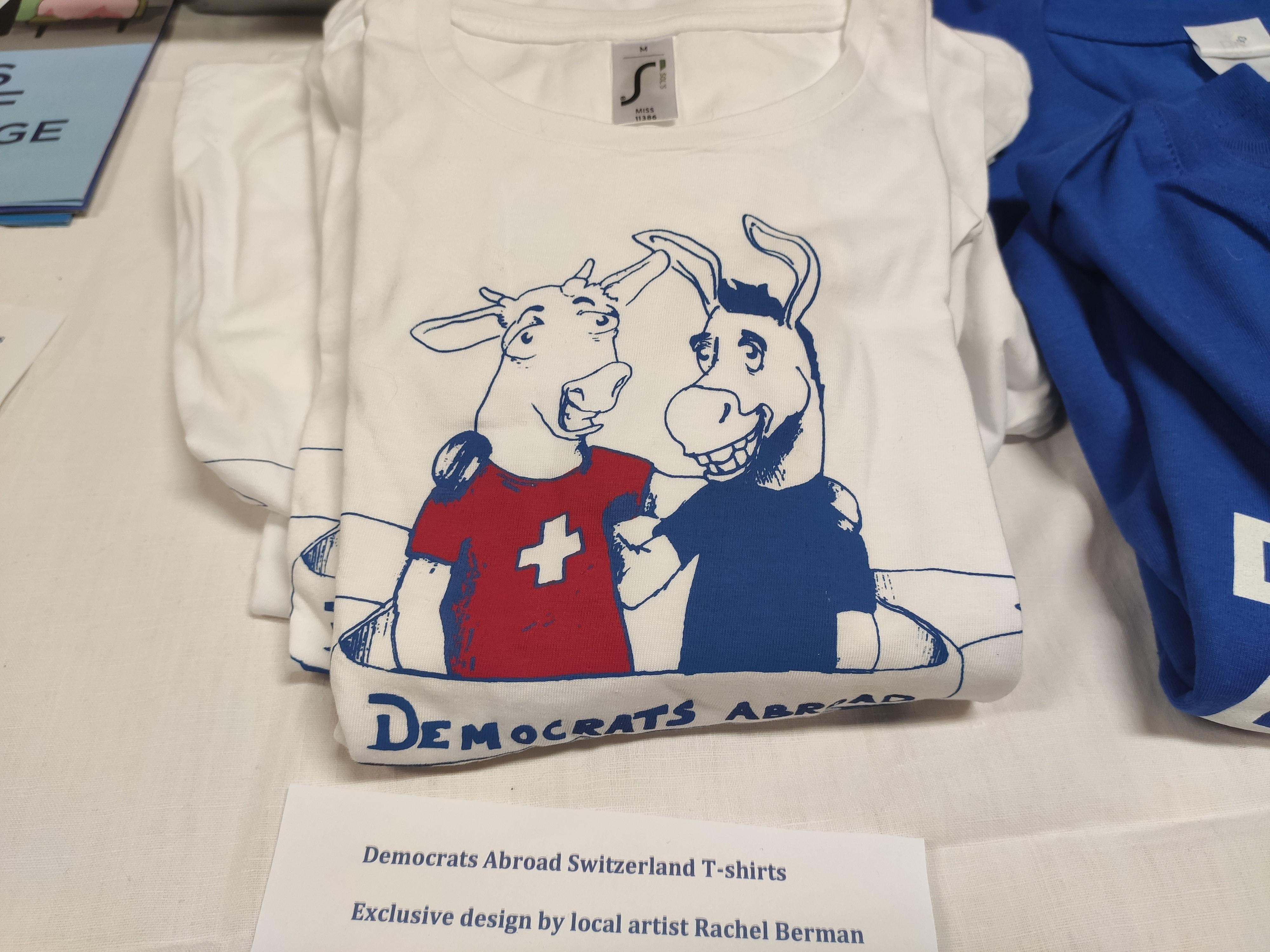 Un t-shirt des Democrats Abroad présente un âne, symbole des Démocrates, enlaçant une vache suisse. [RTS - Mouna Hussain]