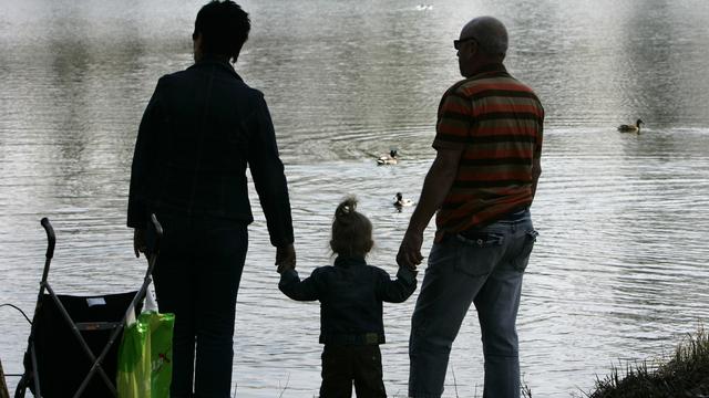 Des grand-parents et leur petite-fille au bord d'un lac. [AP/Keystone - Thomas Kienzle]